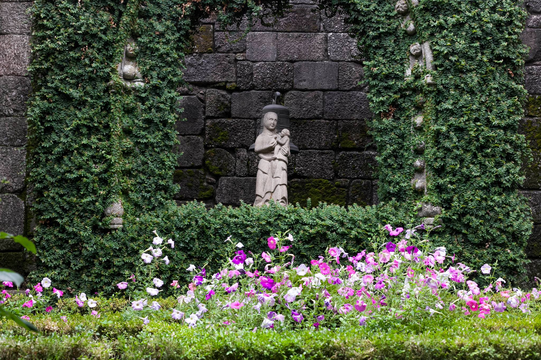 Jardim florido com amores e escultura de Nossa Senhora da Pombinha. Claustro do Museu.