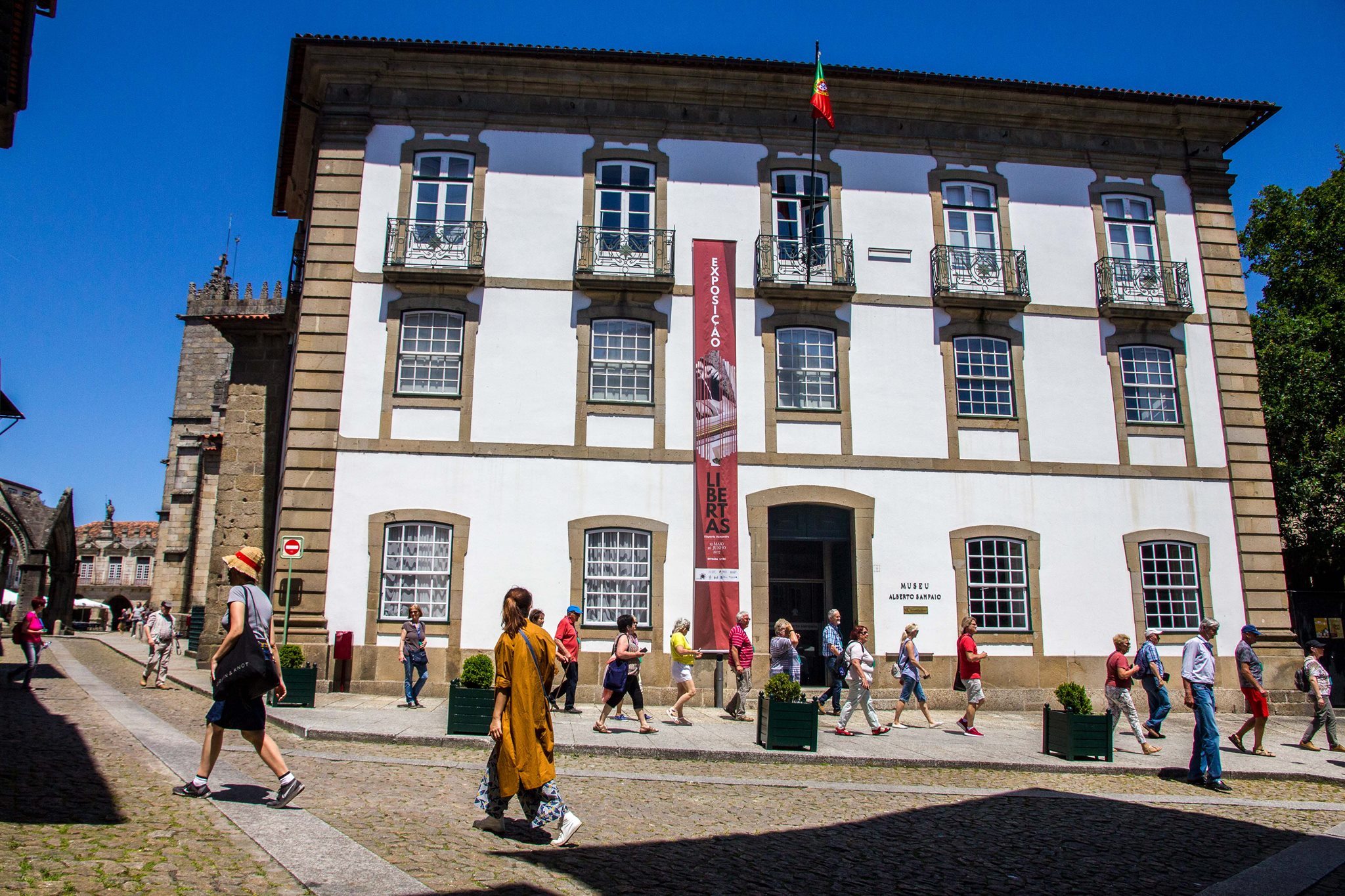 Vista da fachada principal do Museu de Alberto Sampaio com transeuntes