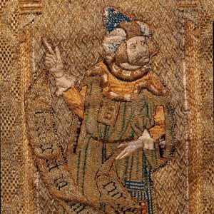 Figura segurando filactera. Pormenor de dalmática do século XVI, de veludo carmim lavrado a fio metálico.