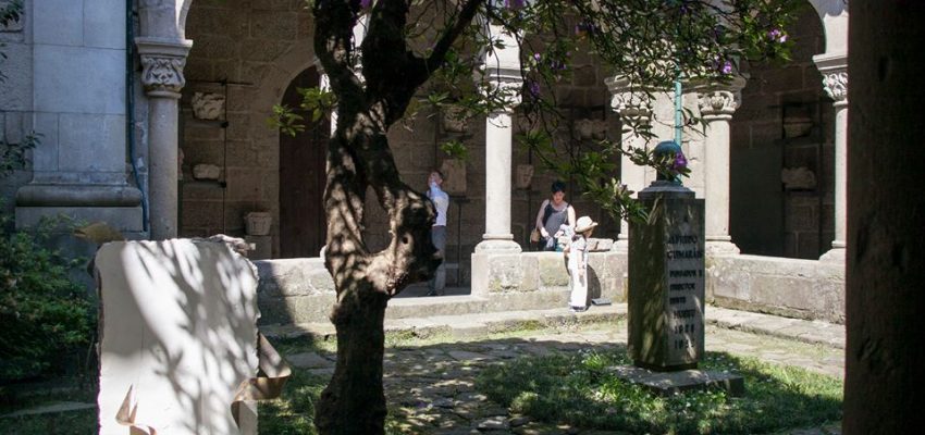 Área nororeste do claustro, com jardim e visitantes.