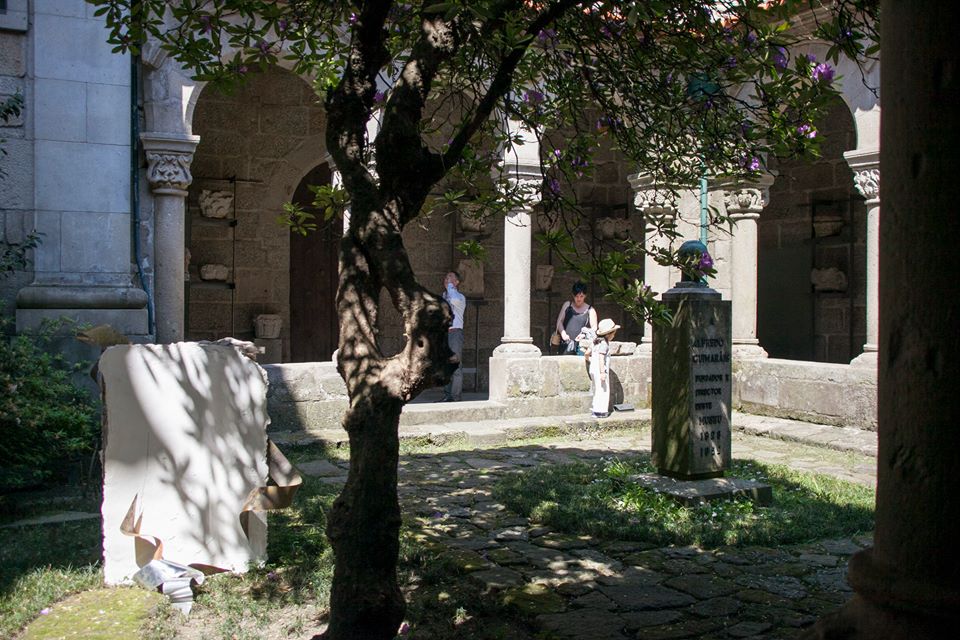 Área nororeste do claustro, com jardim e visitantes.