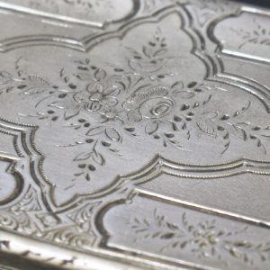 Motivos florais. Pormenor de caixa de rapé em prata branca e dourada. Século XIX.