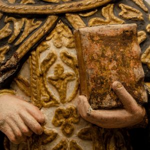 Mão segurando livro. Pormenor da escultura em calcário policromado de São Tomás. Século XVI.